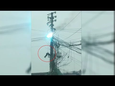 man gets stuck on burning power pole